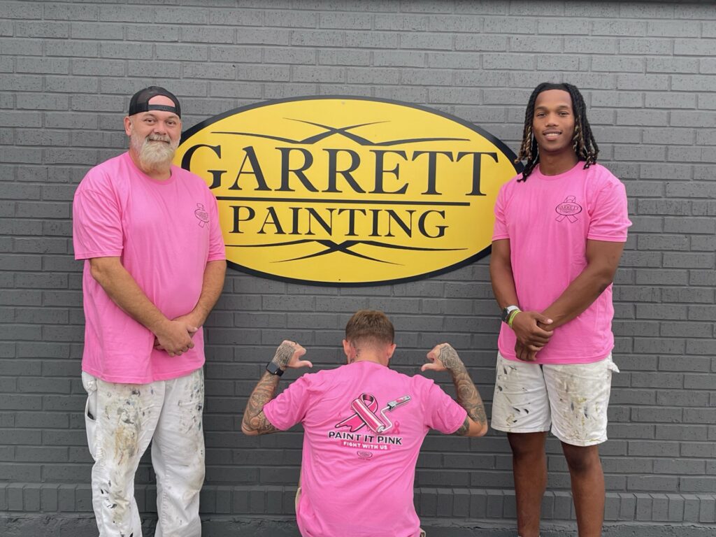 Garrett Painting team members Jared Allen, Tyler Russell and Jaivon McDaniel in pink shirts